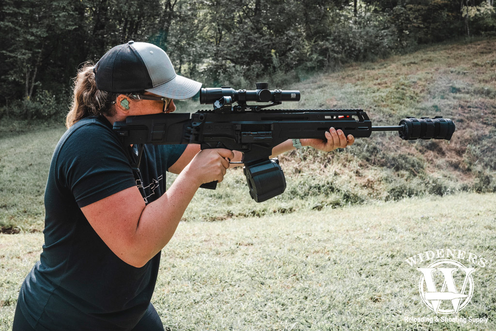 a photo of a female shooting a rifle at a gun range
