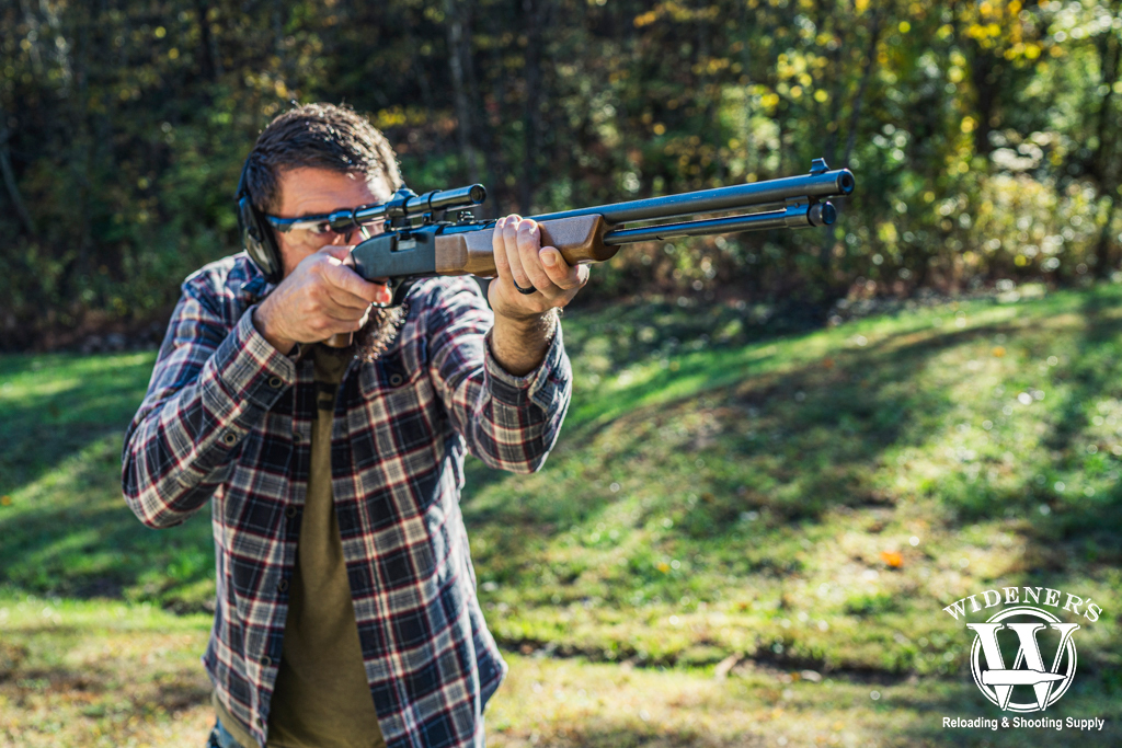 a photo of a man shooting a rimfire rifle outdoors.