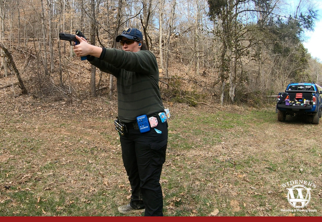 a photo of a female shooting a handgun outdoors